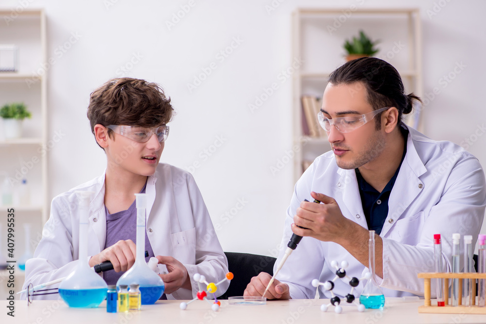 Young father and son chemists in the lab Young father and son chemists in the lab