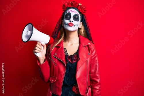 Woman wearing day of the dead costume using megaphone looking at the camera blowing a kiss being lovely and sexy. love expression.