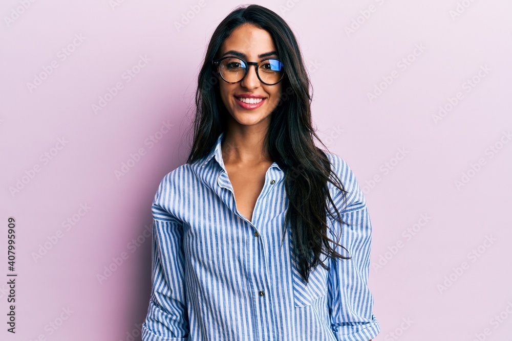 Beautiful hispanic woman wearing casual clothes and glasses with a happy and cool smile on face. lucky person.