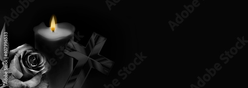 Foto Rose, cross and candle on black background
