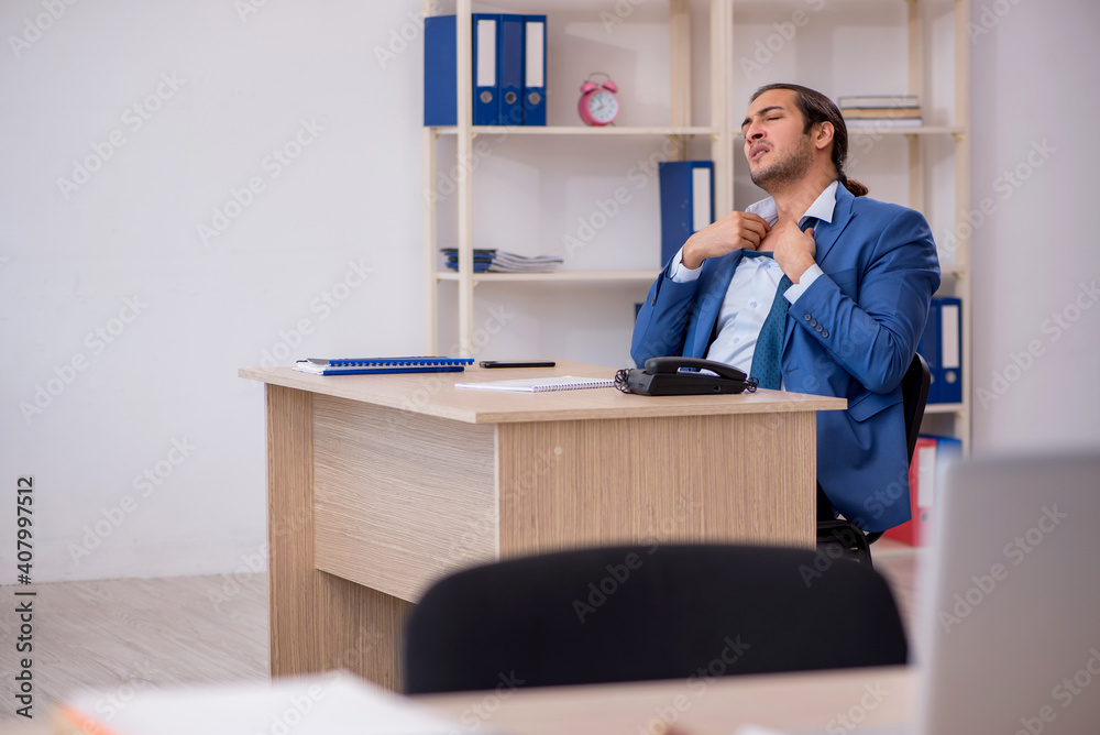 Young male employee and too much work in the office