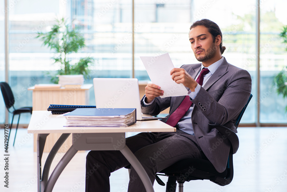 Young male employee working in the office Young male employee working in the office