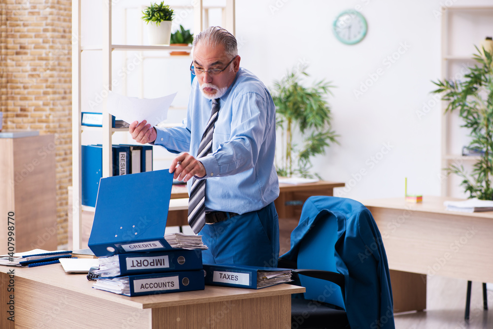Old male bookkeeper unhappy with excessive work at workplace Old male bookkeeper unhappy with excessive work at workplace