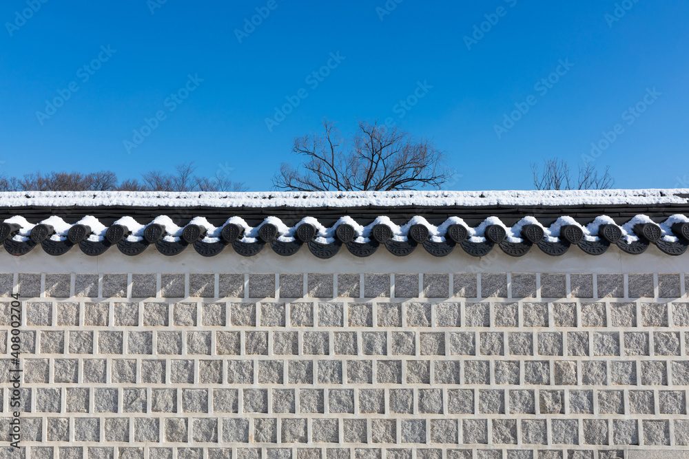 Naklejka premium Winter in Korea. White snow is covered over beautiful traditional stone walls.