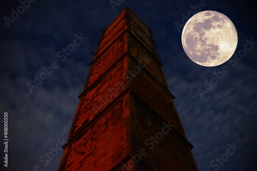 レンガ造りの古い煙突と満月の夜景