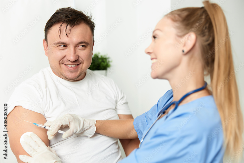 Obraz premium male patient next to doctor woman injection health covid vaccination