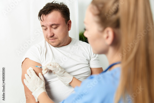 a doctor gives an injection to a man's hand health vaccination