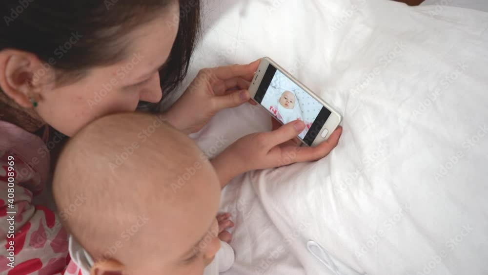 Mom and newborn daughter are watching photos on the phone Mom and newborn daughter are watching photos on the phone