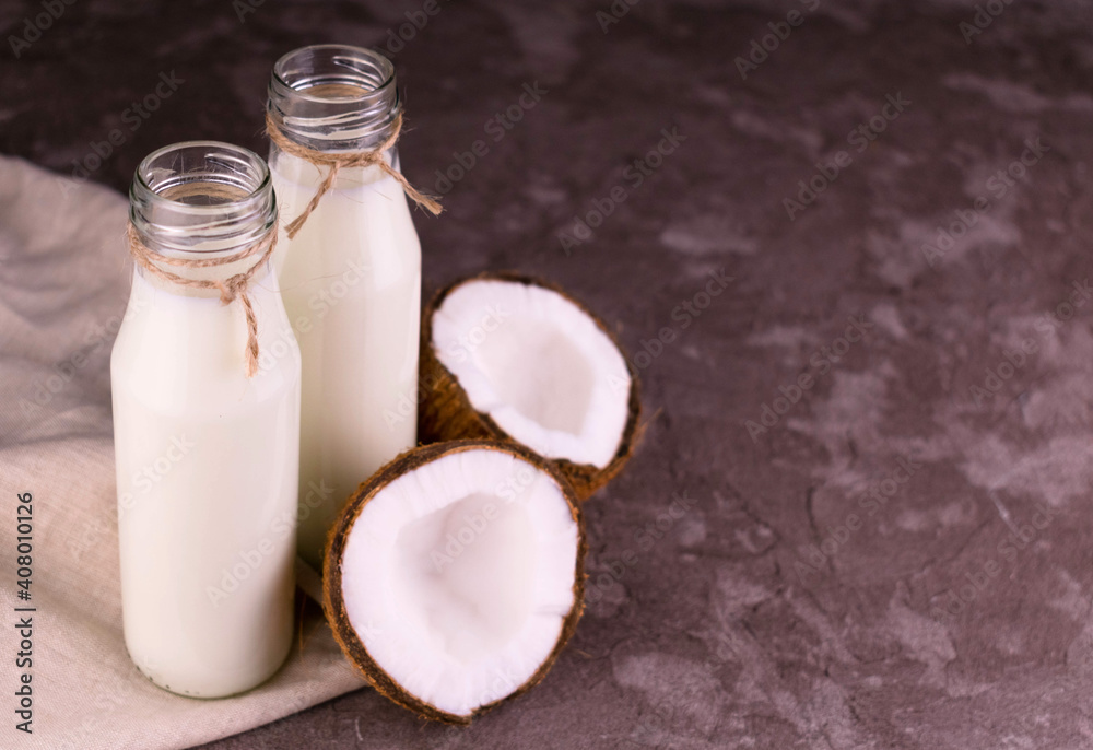 Coconut milk in bottles on gray background.Copy space. Coconut milk in bottles on gray background.Copy space.