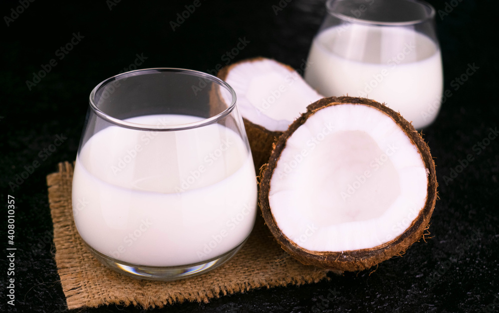 Two glasses with organic coconut milk on a black background. Two glasses with organic coconut milk on a black background.