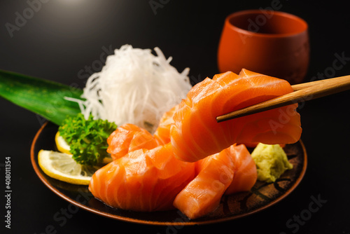 Sashimi, Salmon, Japanese food chopsticks and wasabi with black plate
