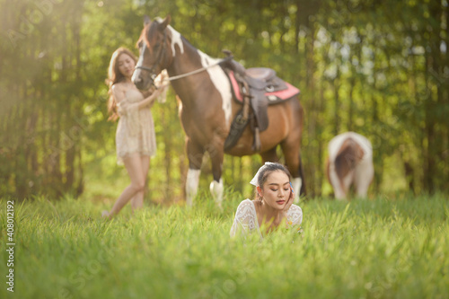 Beautiful asian woman spending a tranquil moment with a horse.Pretty Asian woman petting horse in a farm.