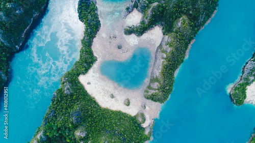 Aerial top view of Love Lagoon Karwapop with turquoise water in heart shape inside of rocky tropical island on Raja Ampat, Papua, Indonesia. photo