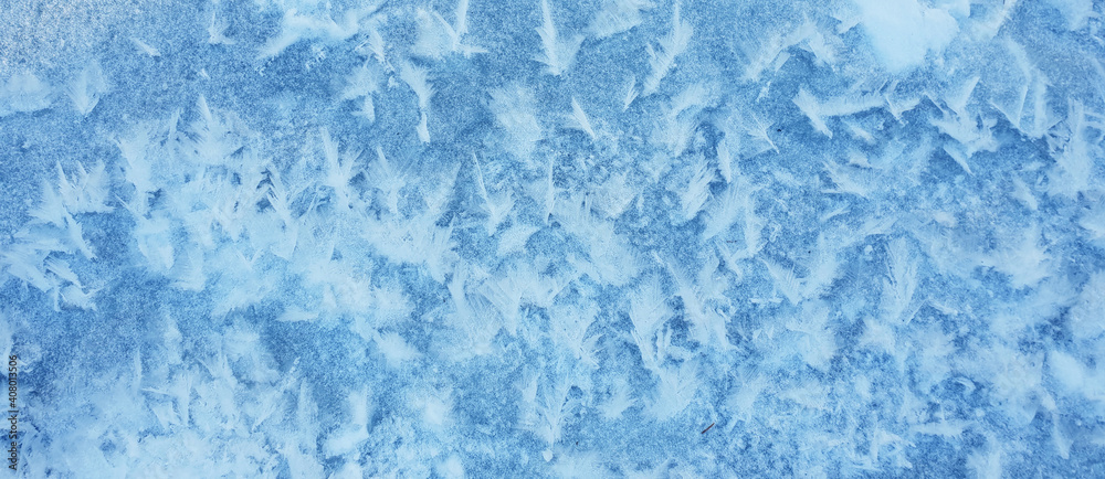 Snow crystals form beautiful snow pattern on frozen icy river. Snowflake background. Snow crystals form beautiful snow pattern on frozen icy river. Snowflake background.