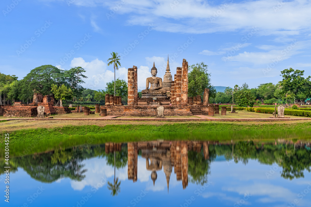 Buddha statue and Pagoda in ruined monastery complex at Wat Mahathat temple with reflection, Sukhothai Historical Park, Thailand Buddha statue and Pagoda in ruined monastery complex at Wat Mahathat temple with reflection, Sukhothai Historical Park, Thailand