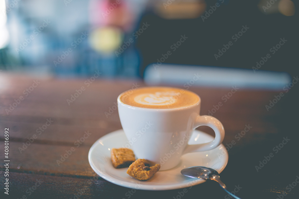 Latte hot coffee with foam milk art on a wooden table