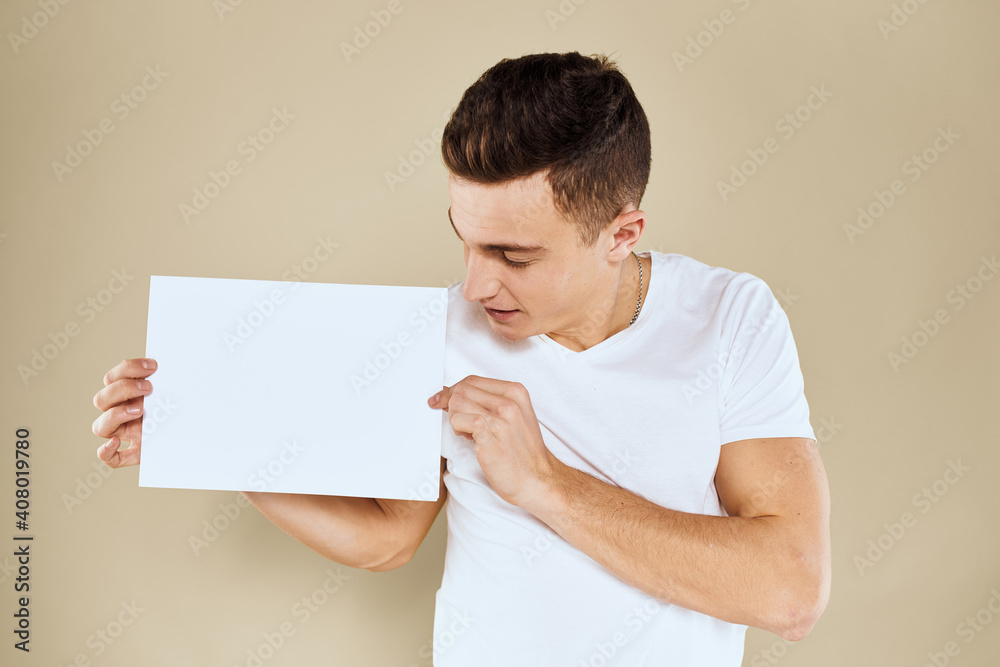 man in white t-shirt sheet of paper in hands Copy Space cropped view beige background man in white t-shirt sheet of paper in hands Copy Space cropped view beige background