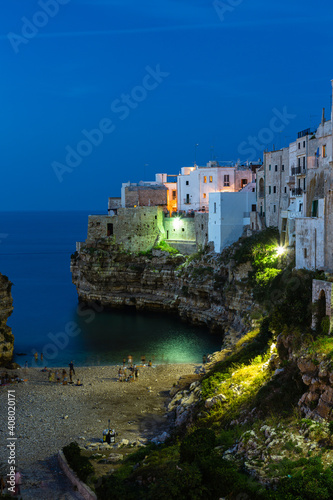 イタリア　ポリニャーノ・ア・マーレの夕暮れ時のカラ・ポルト海岸と断崖の上の旧市街