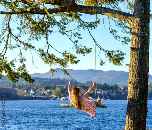 Girl swinging on tree at the ocean - Whiffen Spit, Sooke, British Columbia, Canada  photo
