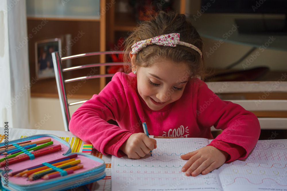 Smiling 6 year old girl does her homework Smiling 6 year old girl does her homework
