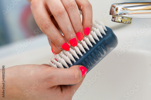 Female washing her hands, using soap brush