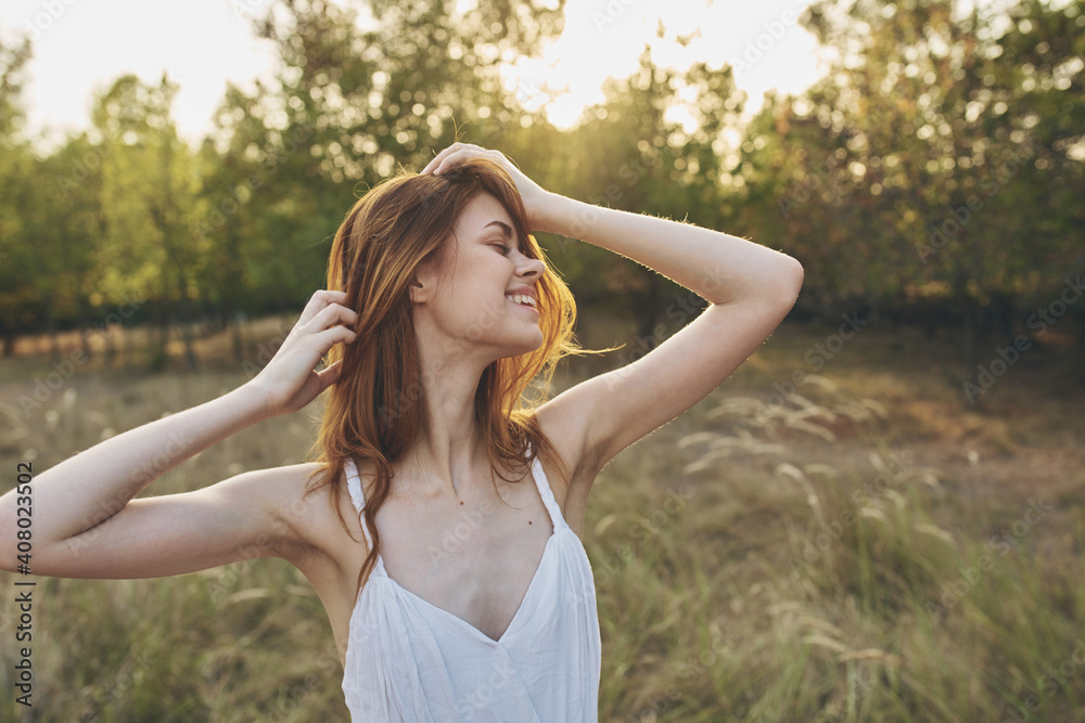 happy traveler in a field among tall trees and dry grass model vacation