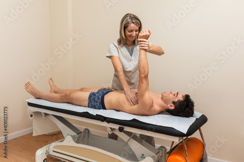 Woman physiotherapist does session to man. tendonitis, glenohuneral photo