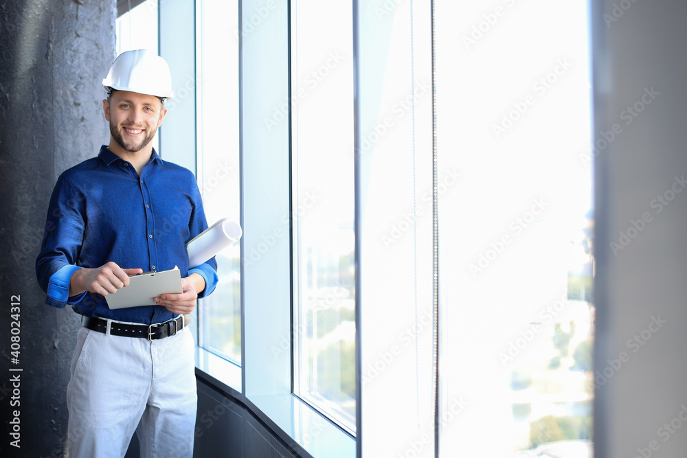 Shot of smiling male architect wearing hardhat and inspecting new building. Shot of smiling male architect wearing hardhat and inspecting new building.