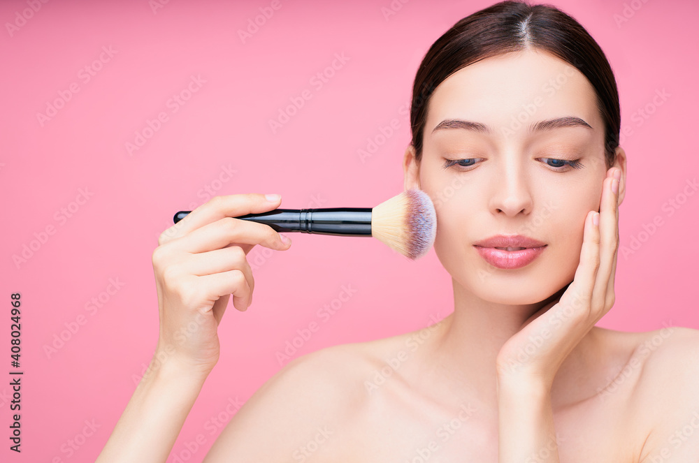 Pretty woman applying make up with brush. Pretty woman applying make up with brush.