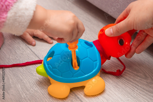 little child with mother, teacher play educational toys, lay and arrange colorful figures. Learning through experience concepts, rough and fine motor skills.
