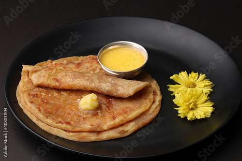 Puran Poli, also known as Holige, is an Indian sweet flatbread from India consumed mostly during Holi festival. Served in a plate with pure Ghee. photo