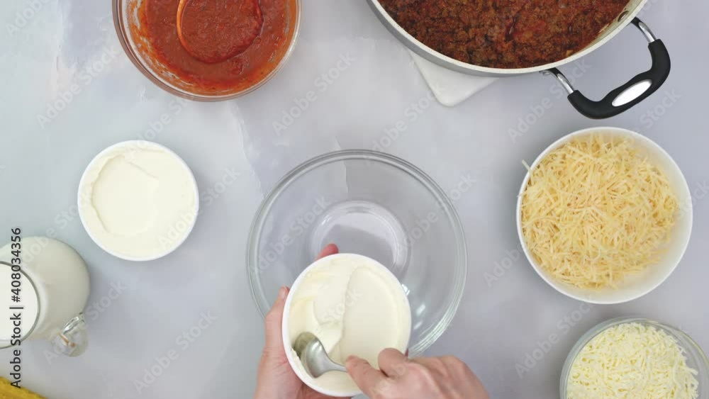 Chef puts cream cheese into a glass bowl. Step by step beef lasagna recipe. Close up video, view from above Chef puts cream cheese into a glass bowl. Step by step beef lasagna recipe. Close up video, view from above