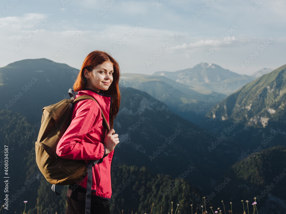 Hiker with a backpack in the mountains in nature and a pink jacket leggings Hiker with a backpack in the mountains in nature and a pink jacket leggings
