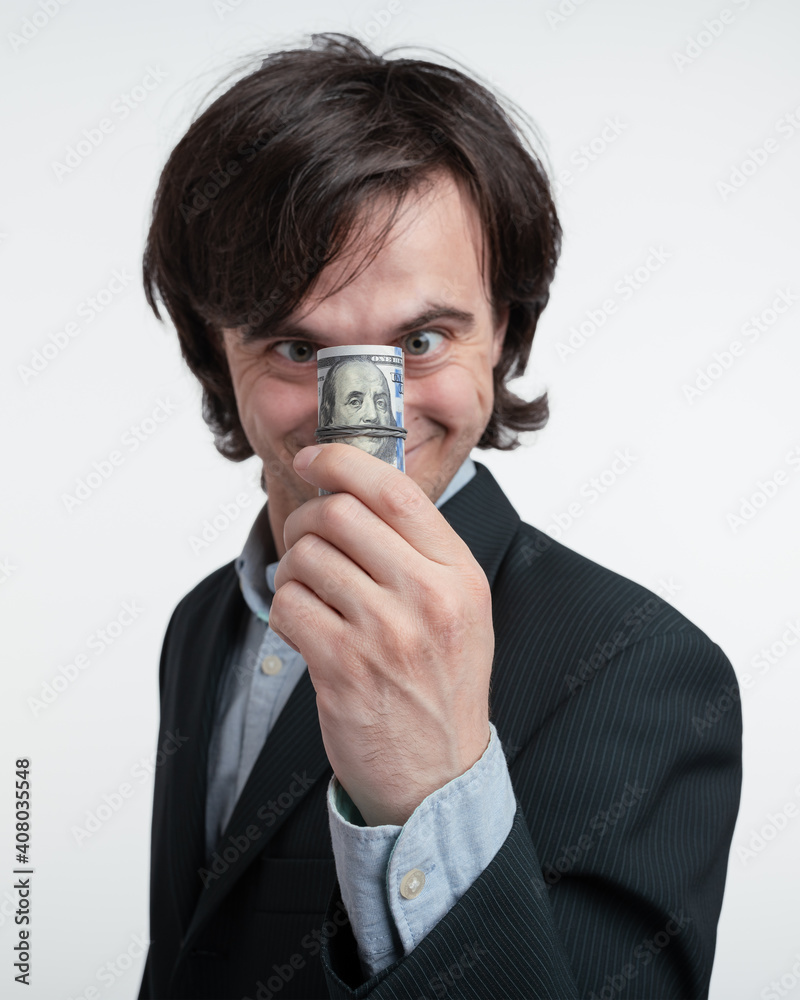 Weird young businessman looking on stack of money