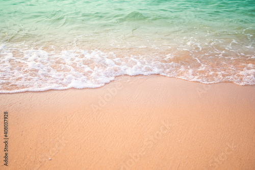 Sand beach with white sea soft wave on top view for assembling an article about travel in summer holiday or ocean coast nature.