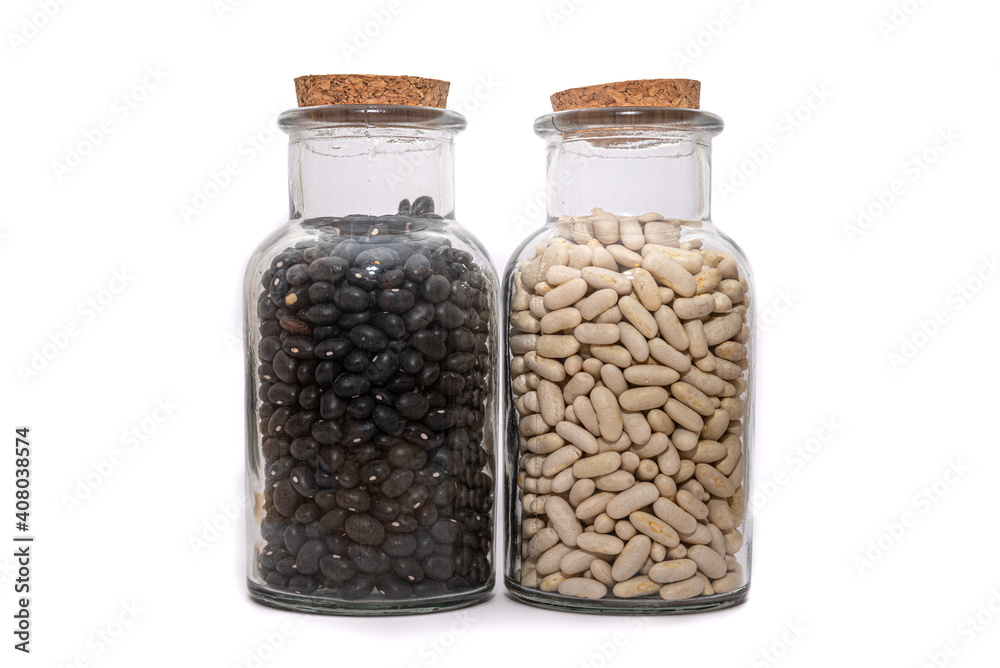 White Beans And Black Bean dried and preserved in glass jars isolated on a white background. Healthy nutritional preserved ingredients. White Beans And Black Bean dried and preserved in glass jars isolated on a white background. Healthy nutritional preserved ingredients.
