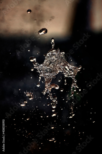 Water liquid splashing on isolated black background. © Onuchcha