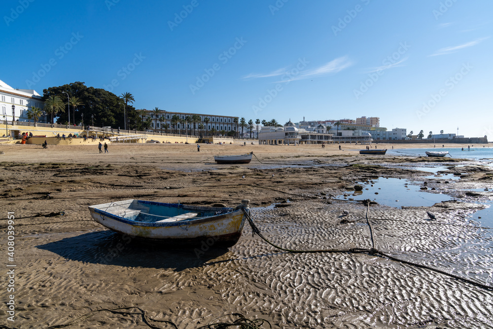 view of La Caleta beach in Cadiz with wooden fishing boats stranded at low tide