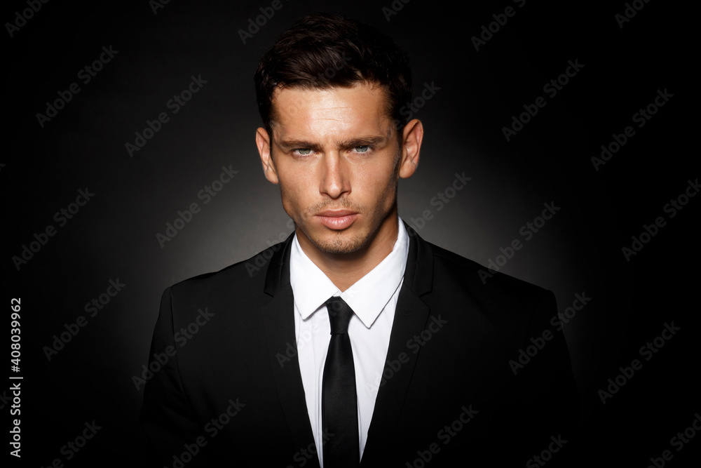 Closeup front portrait of a handsome confident businessman wearing suit standing isolated over black background. Closeup front portrait of a handsome confident businessman wearing suit standing isolated over black background.