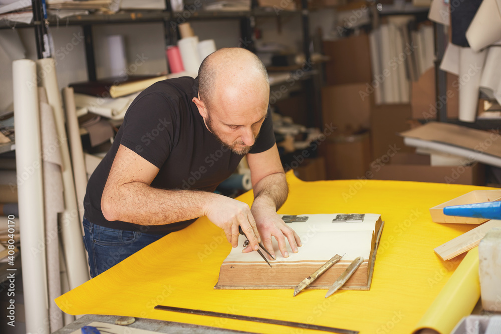 book binder restores old book in craft workshop book binder restores old book in craft workshop