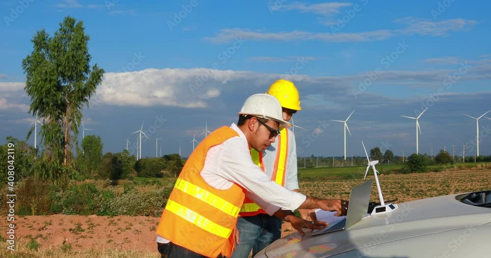 group of asian engineer discussing with his team about project at wind farm group of asian engineer discussing with his team about project at wind farm