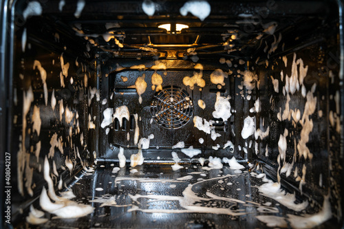 the oven is covered with cleaning foam. home cleaning concept