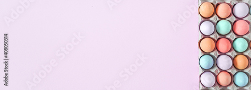 Colorful Pastel Easter eggs on pink background, top view with natural light. Flat lay style, copy space