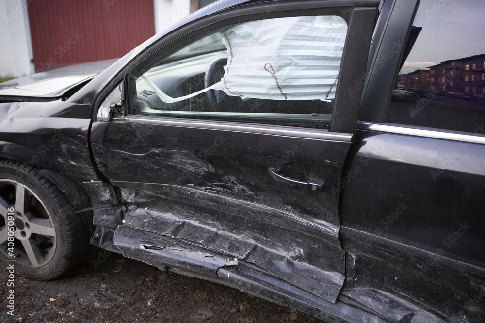 Black car after accident. Crashed car close-up, side view, visible air bag. Black car after accident. Crashed car close-up, side view, visible air bag.