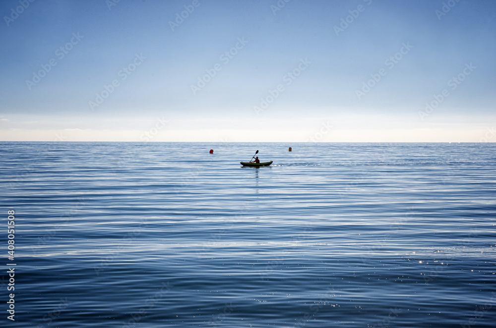 Minimalistic picture of kayak on the sea in Málaga, Spain. Relaxing sport in tranquil water.