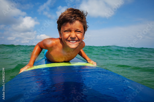 Photography Close portrait of the boy on the surfing board smiling to the camera with funny