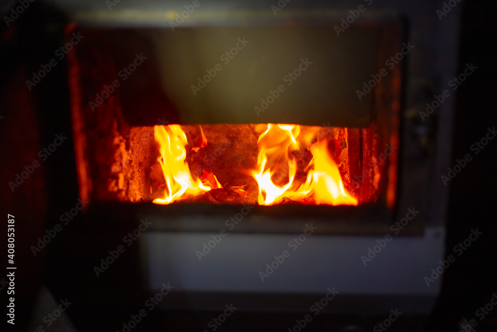 Fuel stove with burning coals. Heating the house in winter