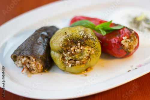 Stuffed bell pepper, red pepper and eggplant on a white plate