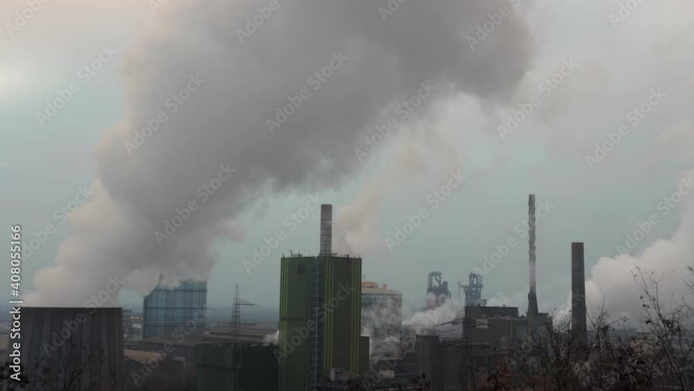 Cooling towers of a factory releasing white smoke to atmosphere. Global warming Cooling towers of a factory releasing white smoke to atmosphere. Global warming