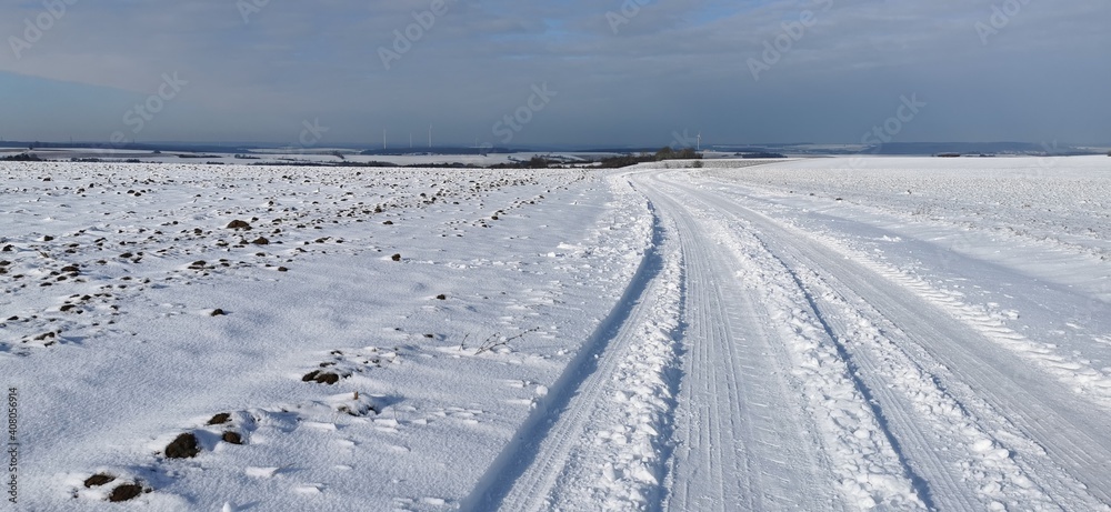 Winter landscape with snowy fields and blue sky